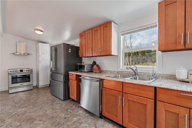 kitchen featuring light stone countertops, appliances with stainless steel finishes, sink, and wall chimney range hood