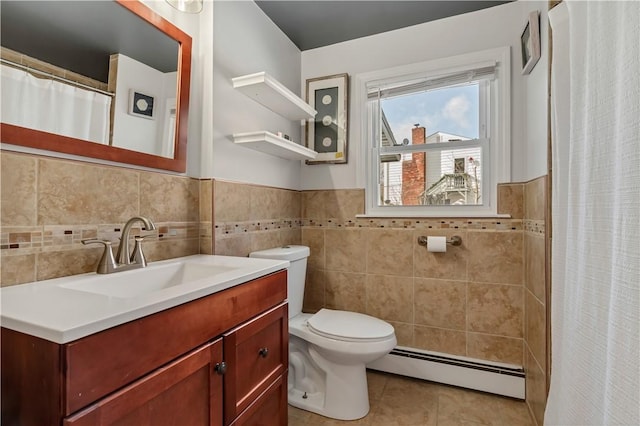 bathroom with toilet, tile walls, vanity, tile patterned flooring, and a baseboard heating unit