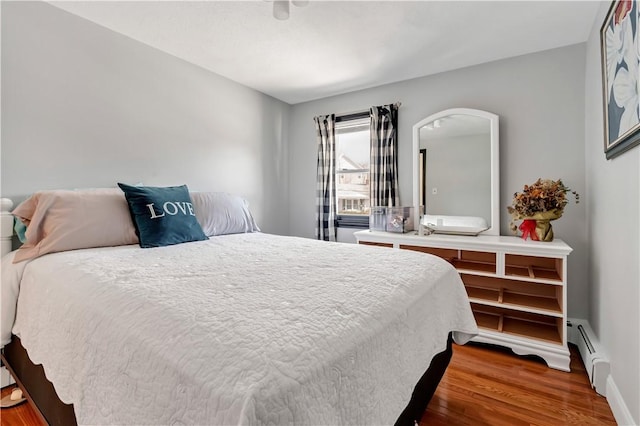 bedroom with a baseboard radiator and dark hardwood / wood-style floors