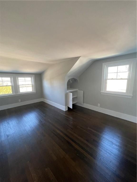 additional living space with lofted ceiling and dark hardwood / wood-style floors