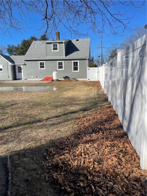 back of property featuring a patio area and a lawn