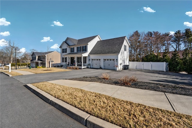 view of front of house with a gate, driveway, a garage, and fence