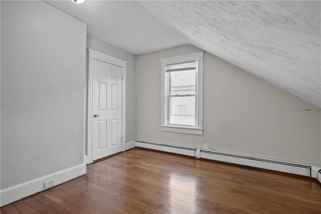 bonus room with hardwood / wood-style flooring, a baseboard radiator, lofted ceiling, and a textured ceiling