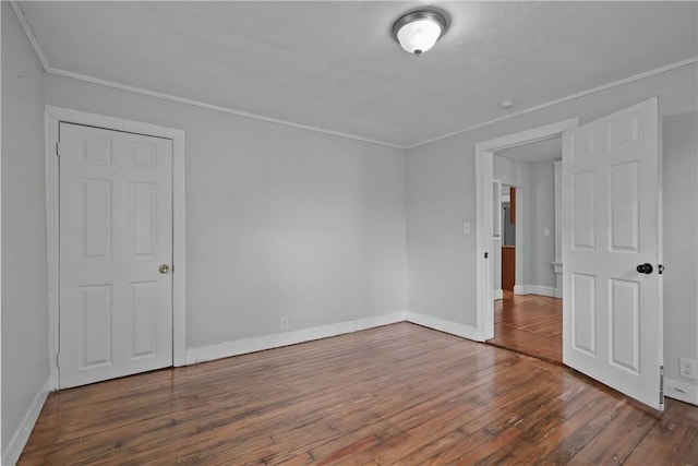 unfurnished room featuring hardwood / wood-style floors and crown molding