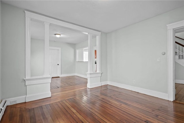 unfurnished room with a baseboard radiator, dark hardwood / wood-style flooring, and decorative columns