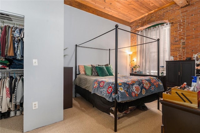 carpeted bedroom featuring brick wall, a spacious closet, wooden ceiling, and a closet