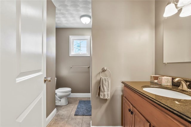 bathroom featuring tile patterned flooring, vanity, and toilet