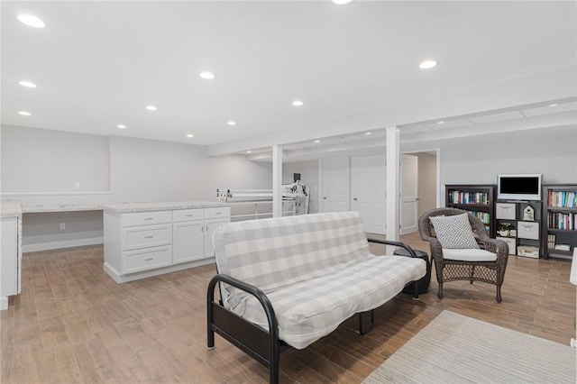 sitting room with baseboards, built in desk, light wood-style flooring, and recessed lighting