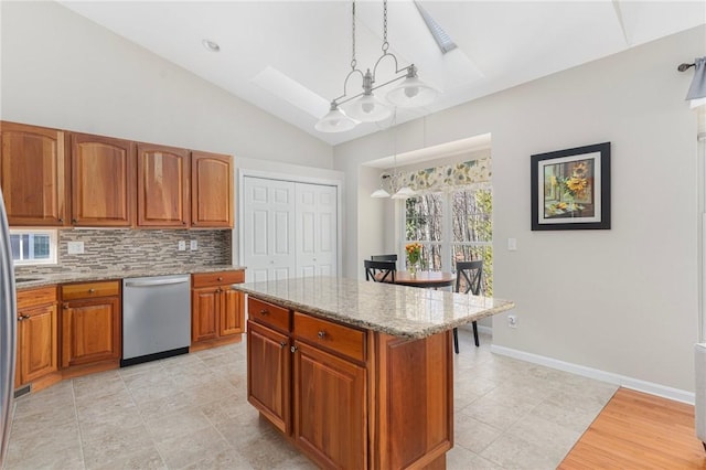 kitchen with light stone counters, a kitchen island, hanging light fixtures, brown cabinets, and dishwasher