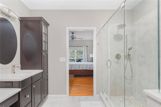 ensuite bathroom featuring a stall shower, ceiling fan, vanity, and ensuite bath