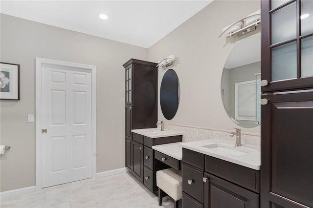 bathroom with double vanity, recessed lighting, a sink, and baseboards