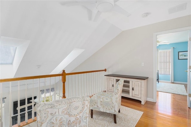 sitting room with lofted ceiling, visible vents, a ceiling fan, light wood-style floors, and baseboards