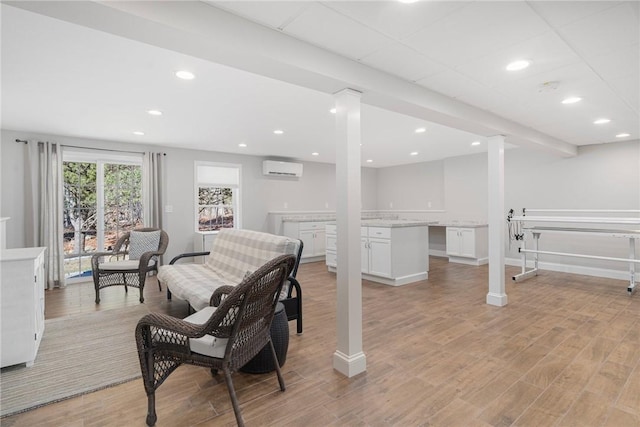 interior space with recessed lighting, a wall unit AC, and light wood-style floors