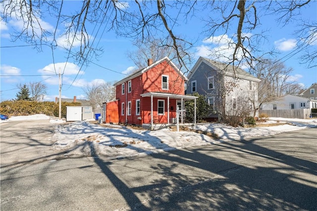 view of front of house featuring a chimney and fence