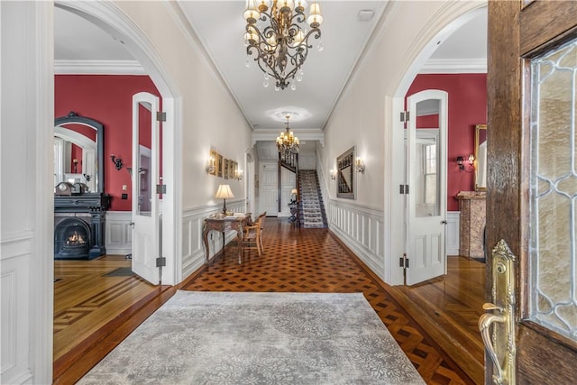 hallway featuring dark hardwood / wood-style flooring, crown molding, and a chandelier