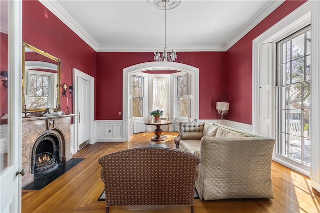 sitting room featuring crown molding, a healthy amount of sunlight, and light parquet floors