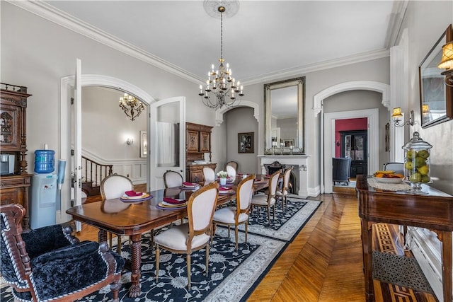 dining area featuring parquet floors, a notable chandelier, and ornamental molding