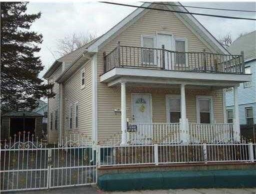 view of front facade featuring a balcony, covered porch, and fence private yard