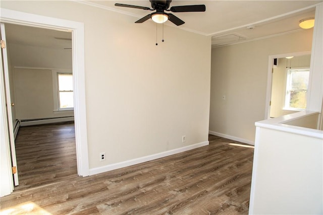 spare room featuring baseboard heating, ceiling fan, ornamental molding, and wood-type flooring