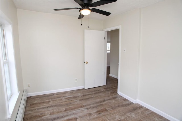 unfurnished room with baseboard heating, ceiling fan, and light hardwood / wood-style flooring