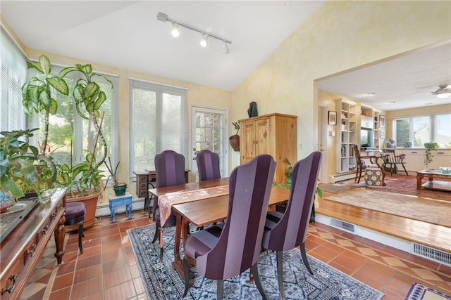 dining room featuring vaulted ceiling, tile patterned floors, and a baseboard radiator