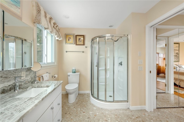 bathroom featuring vanity, an enclosed shower, and toilet