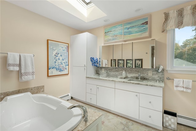 bathroom with a baseboard radiator, a bath, vanity, and a skylight