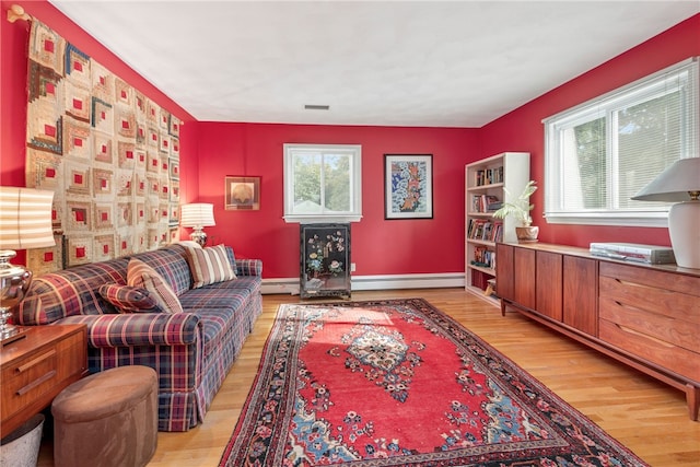 living room with a baseboard radiator, plenty of natural light, and light hardwood / wood-style floors