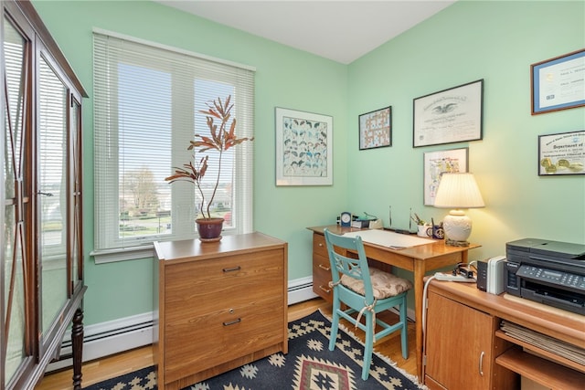 office area featuring a baseboard heating unit and light hardwood / wood-style floors