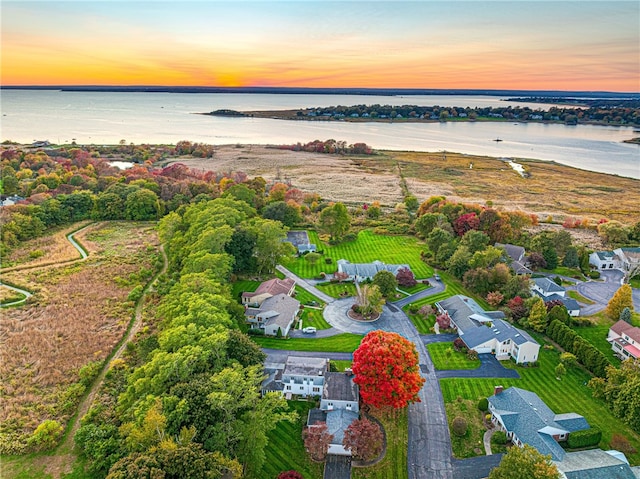 aerial view at dusk featuring a water view