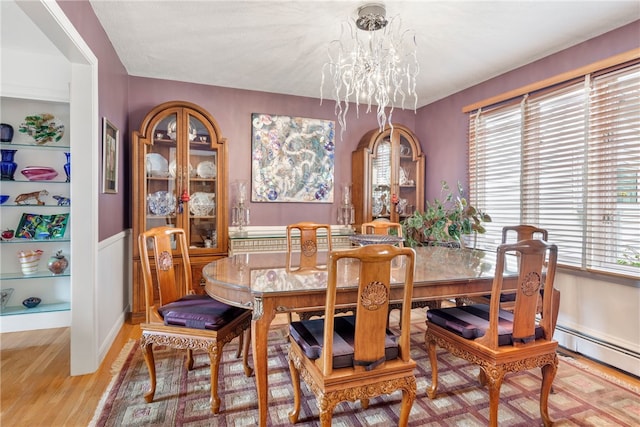 dining area with a chandelier and light hardwood / wood-style flooring