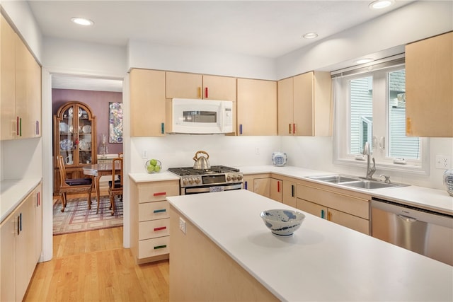 kitchen with light hardwood / wood-style floors, appliances with stainless steel finishes, light brown cabinetry, and sink