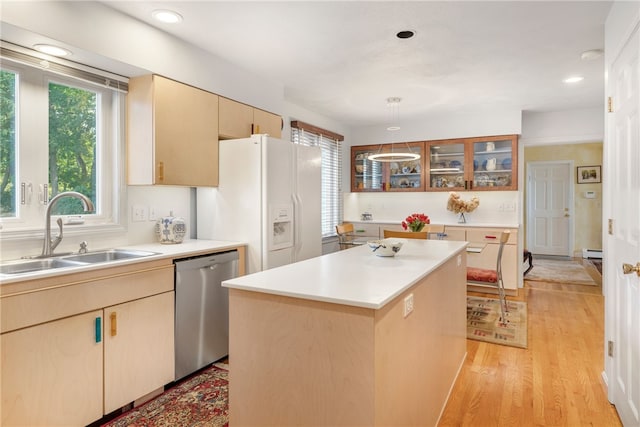 kitchen with a kitchen island, dishwasher, sink, white fridge with ice dispenser, and light hardwood / wood-style flooring