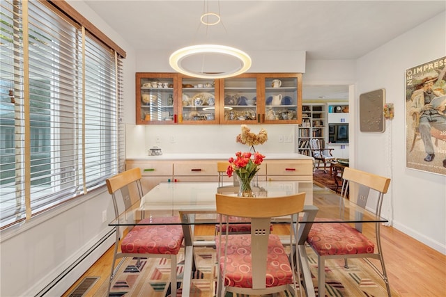 dining space featuring light wood-type flooring and a baseboard heating unit