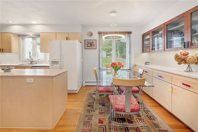 kitchen featuring sink, dishwasher, a baseboard heating unit, white refrigerator with ice dispenser, and light hardwood / wood-style floors