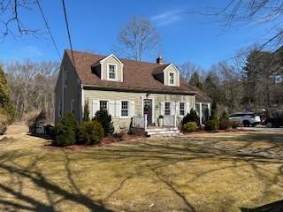 new england style home featuring a front yard