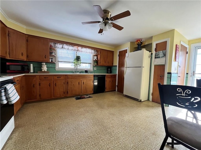 kitchen featuring white refrigerator, a healthy amount of sunlight, black dishwasher, and sink