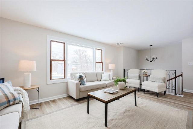 living room featuring an inviting chandelier and light hardwood / wood-style flooring