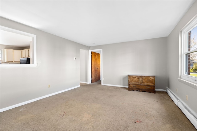 spare room with a baseboard radiator and carpet