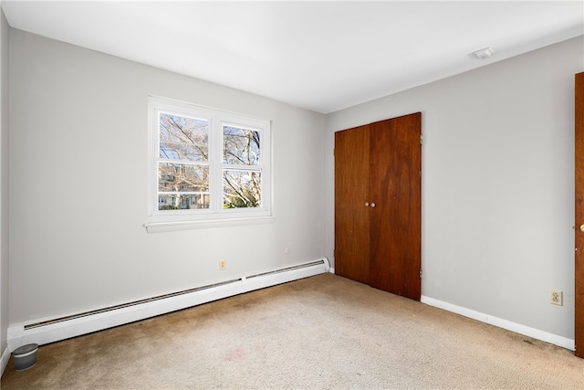 unfurnished bedroom with a baseboard radiator, a closet, and carpet