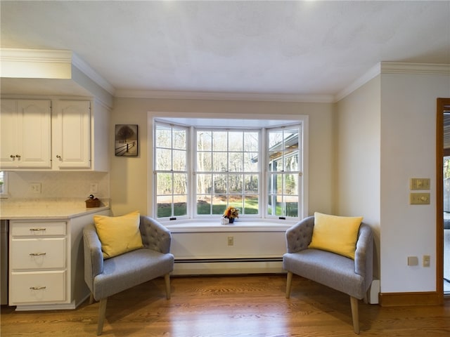 sitting room featuring a baseboard radiator, ornamental molding, and light wood-type flooring