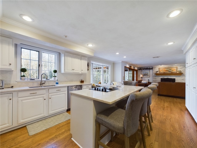 kitchen with stainless steel dishwasher, a center island, and white cabinets