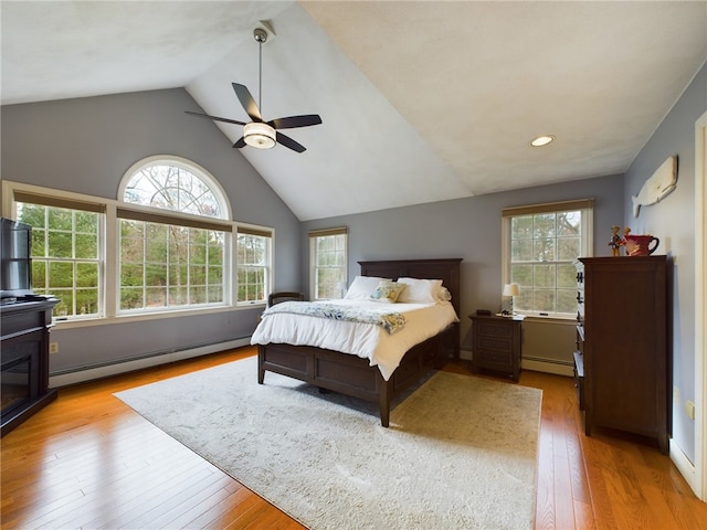 bedroom with ceiling fan, a baseboard radiator, vaulted ceiling, and light wood-type flooring