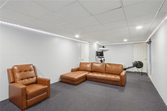 carpeted living room featuring a drop ceiling