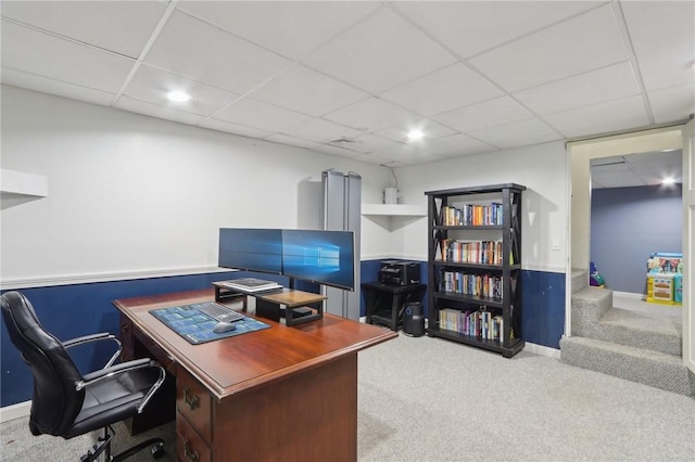 carpeted office with a paneled ceiling