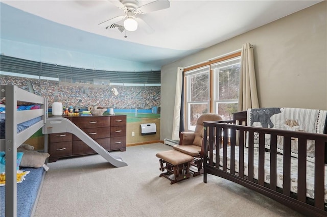 bedroom featuring a baseboard heating unit, light colored carpet, ceiling fan, and heating unit