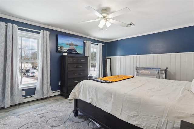 bedroom with ornamental molding, light hardwood / wood-style floors, and ceiling fan