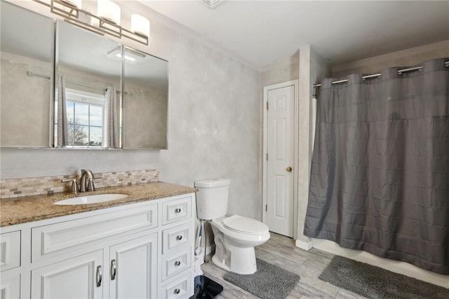 bathroom featuring vanity, hardwood / wood-style floors, backsplash, and toilet