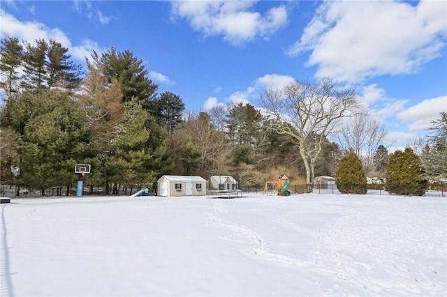 yard covered in snow featuring a playground