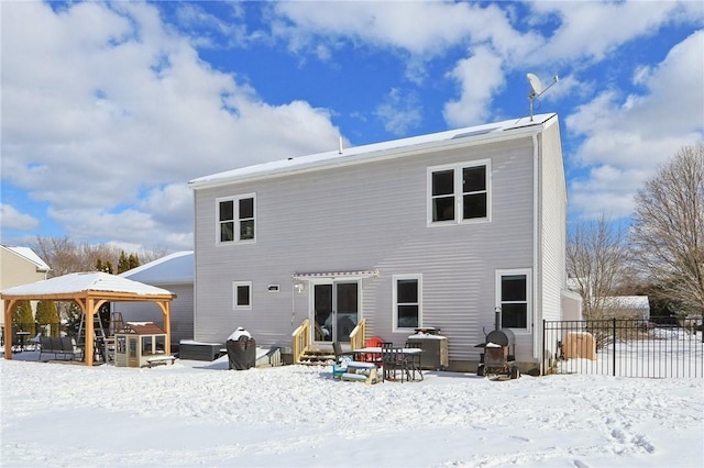 snow covered back of property with a gazebo